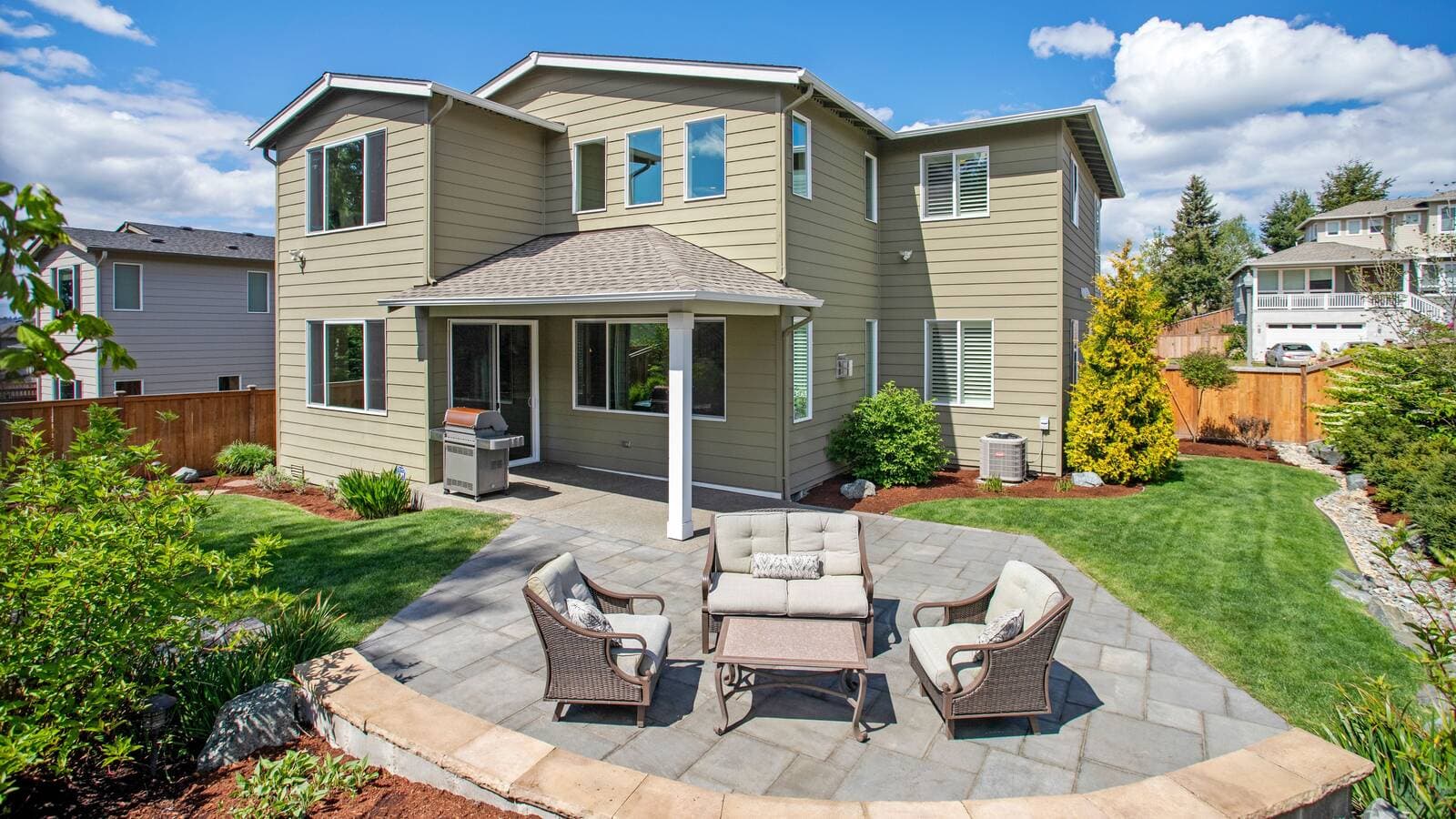 Finished paver patio with outdoor seating behind a home